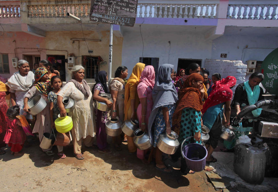 In this March 28, 2014 photo, Indian Muslim women stand in queue to collect drinking water distributed from a water tanker at Juhapura area in Ahmadabad, Gujarat state, India. As India, Asia's third-largest economy, holds elections that will gauge the mood of millions of new voters, Narendra Modi's Hindu nationalist party is proclaiming the economic success of Gujarat. Bharatiya Janata Party faithful say the state's record shows how to re-energize India's sputtering growth, get much needed infrastructure back on track and streamline the tangled bureaucracy that scares away investment.(AP Photo/Ajit Solanki)