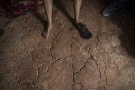 Covered in a disinfectant mist, the body of Susana Cifuentes, who died in her home from symptoms related to COVID-19 at the age of 71, is propped up on a chair as a government team prepares to remove her body, in the Shipibo Indigenous community Pucallpa, in Peru's Ucayali region, Tuesday, Sept. 1, 2020. In the Ucayali region, government rapid response teams deployed to a handful of indigenous communities have found infection rates as high as 80% through antibody testing. (AP Photo/Rodrigo Abd)