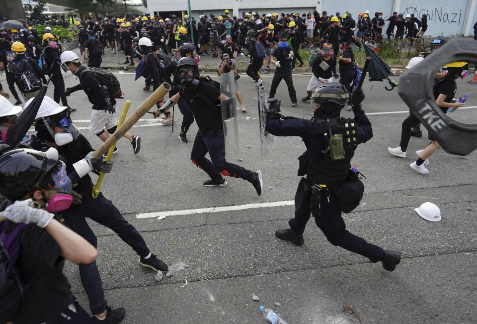Police and demonstrators clash during a protest in Hong Kong, Saturday, Aug. 24, 2019. The protesters were part of a larger group marching to demand the removal of smart lampposts installed in a Kowloon district over fears they could contain high-tech cameras and facial recognition software used for surveillance by Chinese authorities. (AP Photo/Vincent Yu)