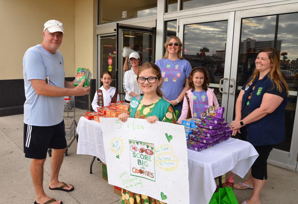 Ron Knight buys some cookies from the scouts. Girl Scout Troop 1509 was set up in front of the Melbourne beachside Winn Dixie on Eau Gallie Blvd. Saturday morning, selling Girl Scout Cookies.