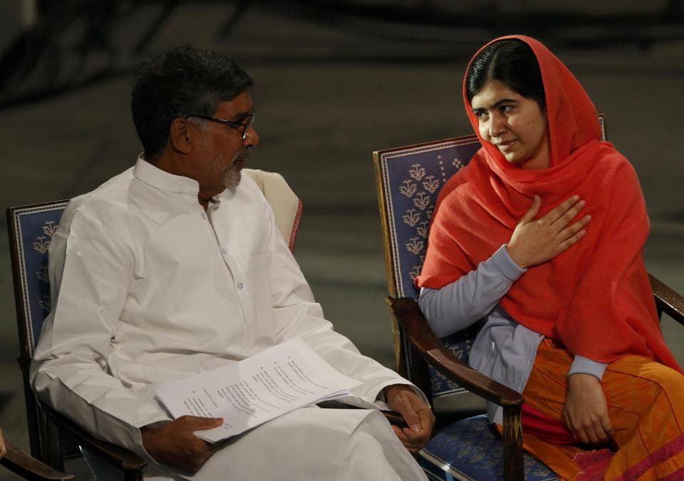 Nobel Peace Prize laureates Malala Yousafzai (R) and Kailash Satyarthi attend the Nobel Peace Prize awards ceremony at the City Hall in Oslo December 10, 2014. Pakistani teenager Yousafzai, shot by the Taliban for refusing to quit school, and Indian activist Satyarthi received their Nobel Peace Prizes on Wednesday after two days of celebration honouring their work for children's rights. REUTERS/Suzanne Plunkett (NORWAY - Tags: SOCIETY)