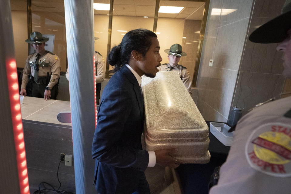 Rep. Justin Jones, D-Nashville, carries a child's casket into the state Capitol past state troopers, Monday, April 17, 2023, in Nashville, Tenn. (AP Photo/George Walker IV)