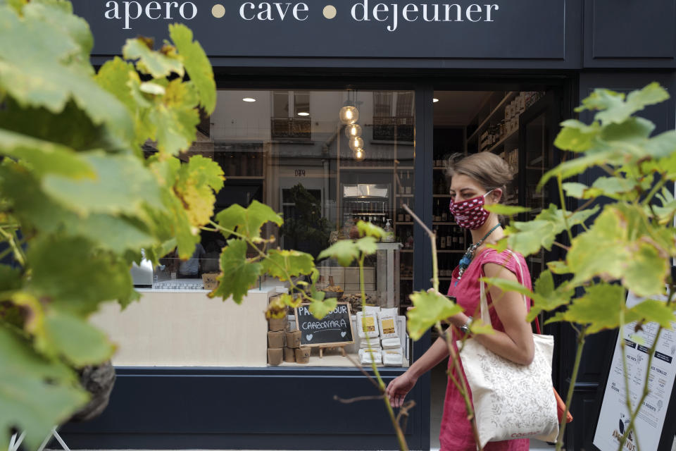 A woman, wearing a protective face mask as a precaution against the coronavirus, walks in Paris, Friday, Sept. 11, 2020. French health authorities have reported on Thursday 9,843 infections from the coronavirus in 24 hours, the highest daily tally since the end of France's lockdown in April. France has seen a sharp uptick in new cases in recent weeks and hospitalizations have started to increase steadily, reaching now over 5,000 including 615 people in ICU. (AP Photo/Francois Mori)