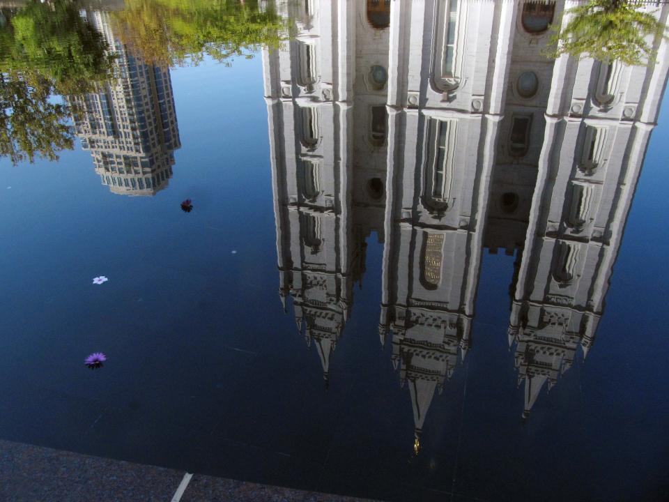 FILE - In this Sept. 30, 2012, file photo, the Mormon temple in Salt Lake City is reflected in a pool. A newly-posted article, part of a series of recent online articles posted on the website of The Church of Jesus Christ of Latter-day Saints, affirms the faith's belief that humans can become like God in eternity, but explains that the "cartoonish image of people receiving their own planets" is not how the religion envisions it. (AP Photo/Shannon Dininny, File)