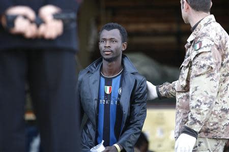 A migrant is helped by an Italian soldier as he arrives at the Sicilian port of Augusta near Siracusa March 21, 2014. REUTERS/Antonio Parrinello