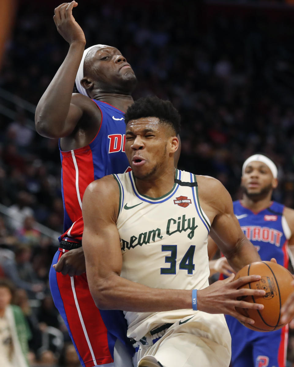 Milwaukee Bucks forward Giannis Antetokounmpo (34) drives on Detroit Pistons forward Sekou Doumbouya during the first half of an NBA basketball game, Thursday, Feb. 20, 2020, in Detroit. (AP Photo/Carlos Osorio)