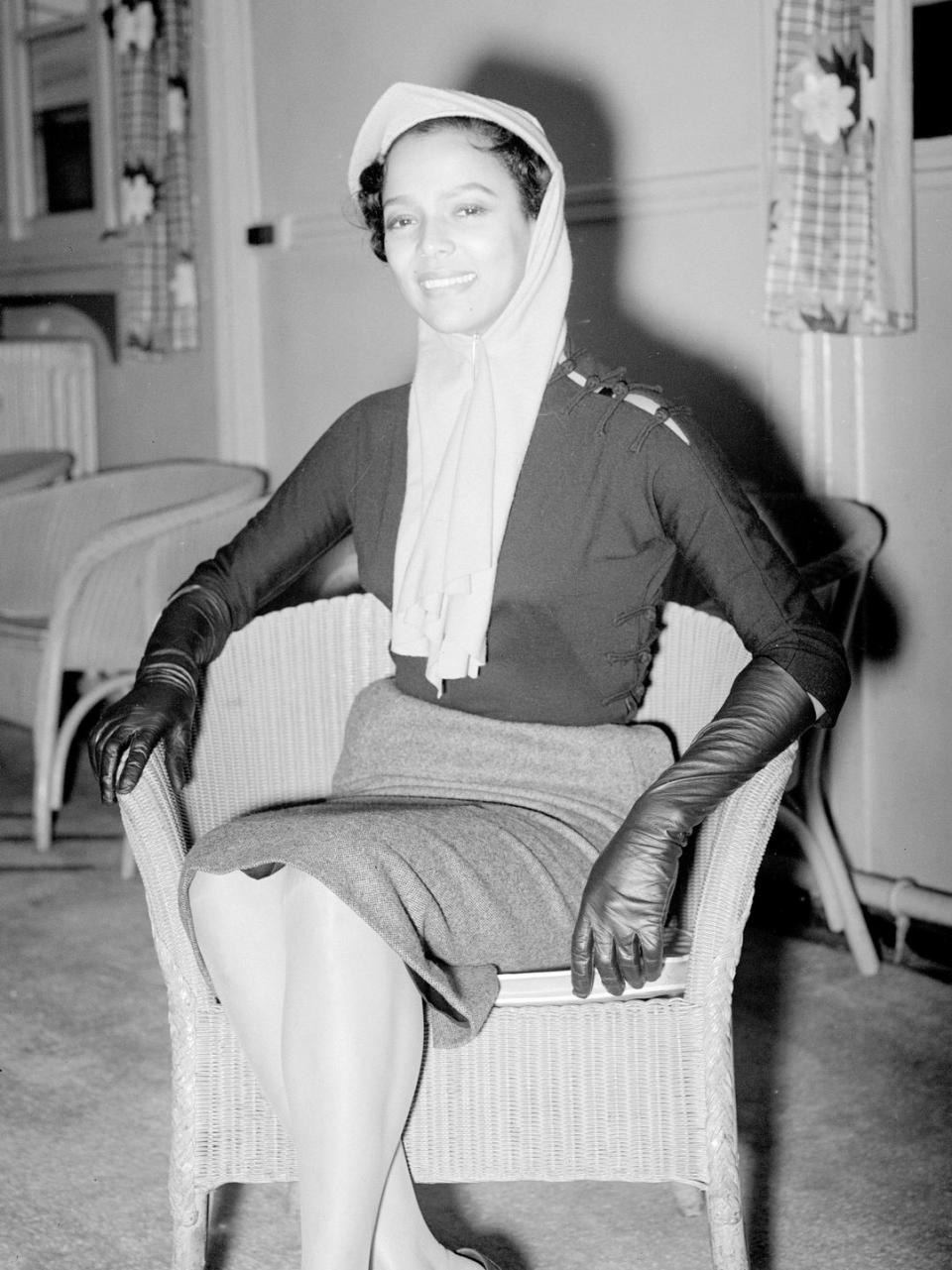 <p>We wish we could look as sophisticated as Dorothy Dandridge when flying home for the holidays. The actress wore a high-waisted skirt, a black turtleneck, leather gloves, and a chic head wrap for her travel day.</p>