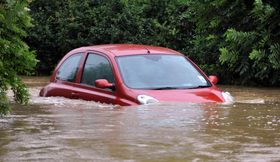 An elderly couple were forced to abandon their their car when it was overwhelmed by flood water from the River Brit in Burton Bradstock, Dorset.