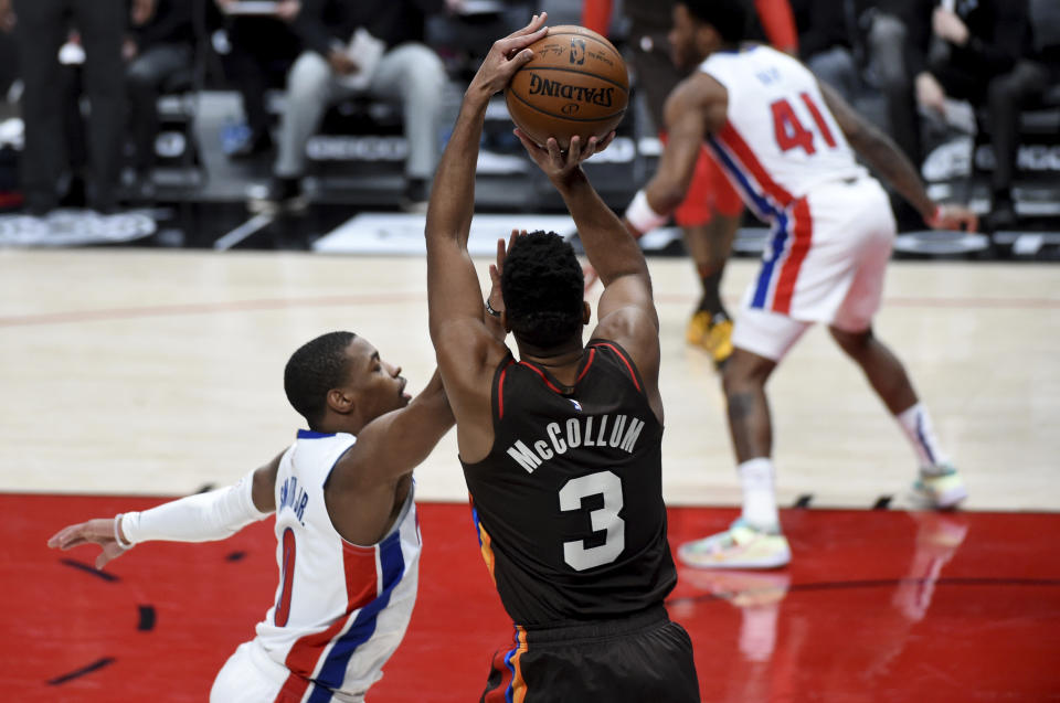 Portland Trail Blazers guard CJ McCollum (3) hits a shot over Detroit Pistons guard Dennis Smith Jr., left, during the second half of an NBA basketball game in Portland, Ore., Saturday, April 10, 2021. The Blazers won 118-103. (AP Photo/Steve Dykes)