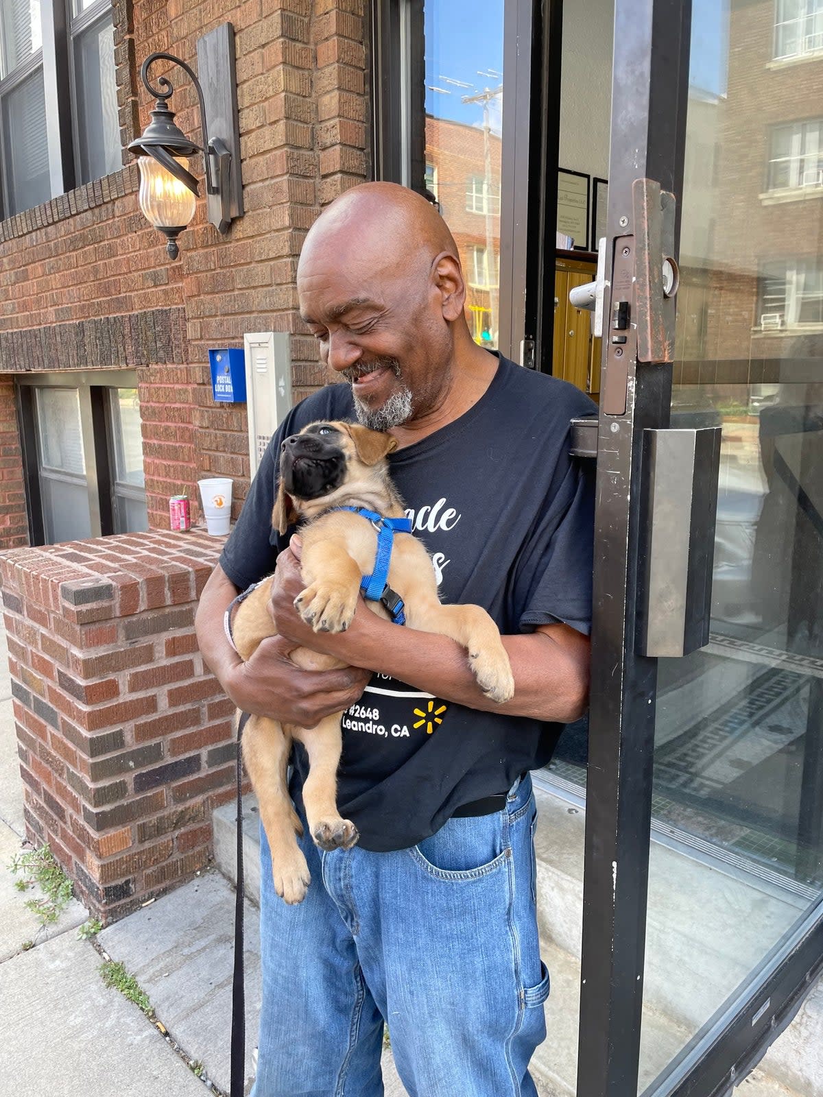 A man holds a puppy and smiles after Minneapolis police returned the stolen canine on August 9, 2024. (Minneapolis police)