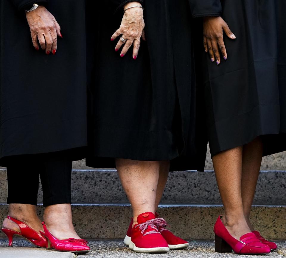 From left, Judges Teresa Lopez, Cathy Riggs and Elaissia Sears prepare for a group photo of the 26 justices of the peace in Maricopa County outside the Maricopa County Courthouse on Friday, Oct. 29, 2021, in Phoenix.