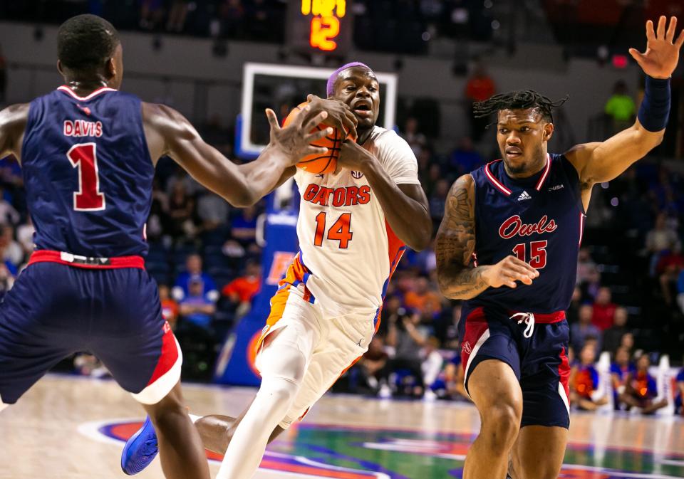 Florida Gators guard Kowacie Reeves (14) drives to the basket in the second half while under pressure from Florida Atlantic Owls guard Johnell Davis (1) and Florida Atlantic Owls guard Alijah Martin (15). The Florida Gators menÕs basketball team hosted the Florida Atlantic Owls at Billy Donovan Court at Exactech Arena in Gainesville, FL on Monday, November 14, 2022. Florida Atlantic defeated Florida 76-74.  [Doug Engle/Gainesville Sun]