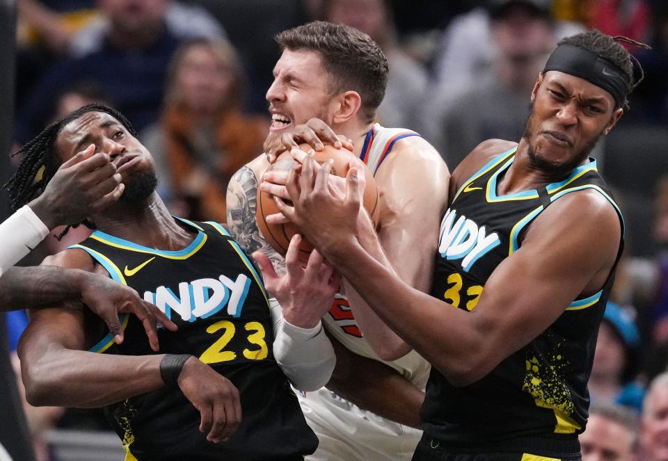 New York Knicks center Isaiah Hartenstein (55) wrestles fort he ball against Indiana Pacers center Myles Turner (33) and Indiana Pacers forward Aaron Nesmith (23) on Saturday, Dec. 30, 2023, during the game at Gainbridge Fieldhouse in Indianapolis. The Indiana Pacers defeated the New York Knicks, 140-126.