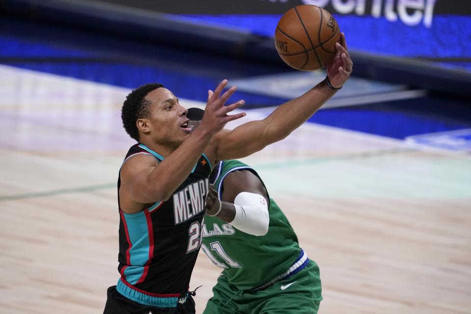 Memphis Grizzlies' Desmond Bane (22) loses control of the ball breaking to the basket as Dallas Mavericks' Tim Hardaway Jr., rear, defends in the first half of an NBA basketball game in Dallas, Monday, Feb. 22, 2021. (AP Photo/Tony Gutierrez)