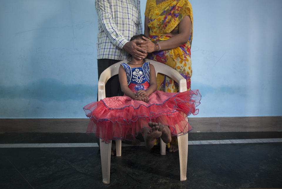 MAHARASHTRA, INDIA - NOVEMBER 12:  5 year old Nirmala (name changed), who was raped by her mother's boss, poses for a photo with her mother and father on November 12, 2015 in Maharashtra, India. One day Nirmala's mother gave her money to go to the corner store and buy food. While Nirmala was walking the man came up to her and offered to buy her candy. He took her to a wooded area behind an apartment building complex, raped her, and inserted a pen inside her. He left her naked and bleeding heavily. She required two surgeries and stayed in the hospital for three months. They caught the man two weeks later. Since he's been in jail, his family keeps coming to Nirmala's family offering them money to drop the court case. Nirmala's family has since moved to a different neighborhood because the neighbors were gossiping, saying things like 'The girl's life is spoiled, what will you do now?'. Nirmala's mother says they won't accept the money offered by the rapist's family, that they want justice instead. (Photo by Getty Images)