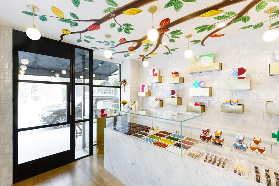 This 2019 photo shows the inside of andSons Chocolatiers in Beverly Hills, Calif., which was designed by Lauren Buxbaum Gordon and Nate Berkus. Homeowners who want to take decorating inspiration from their favorite public places should consider what specific elements they like best, such as appealing lighting. Inside andSons, ample natural light is paired with soft pendant lighting to create a light-filled, inviting space. (Christopher Dibble/Lauren Buxbaum Gordon via AP)