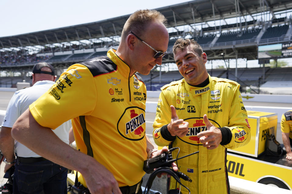 Scott McLaughlin, of New Zealand, talks with a team member during practice for the Indianapolis 500 auto race at Indianapolis Motor Speedway, Friday, May 20, 2022, in Indianapolis. (AP Photo/Darron Cummings)