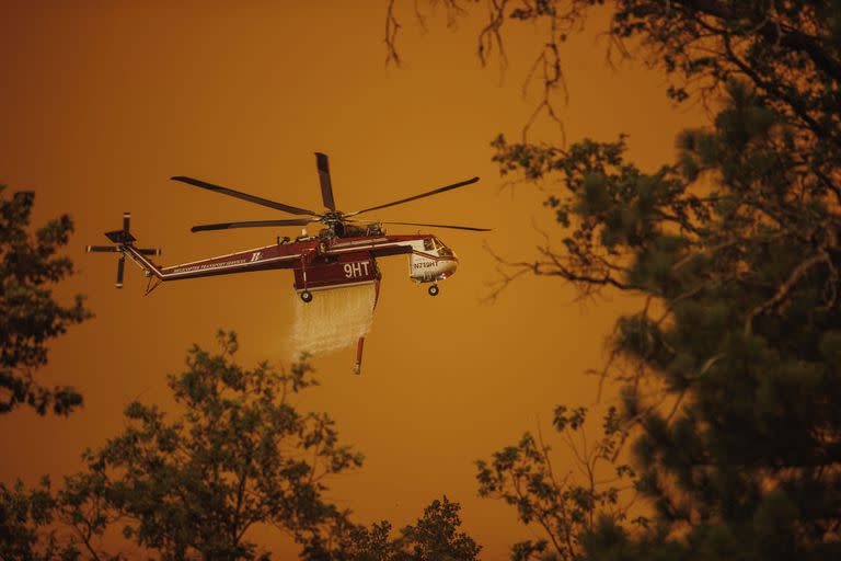 Un helicóptero arroja agua sobre el incendio Oak en Mariposa