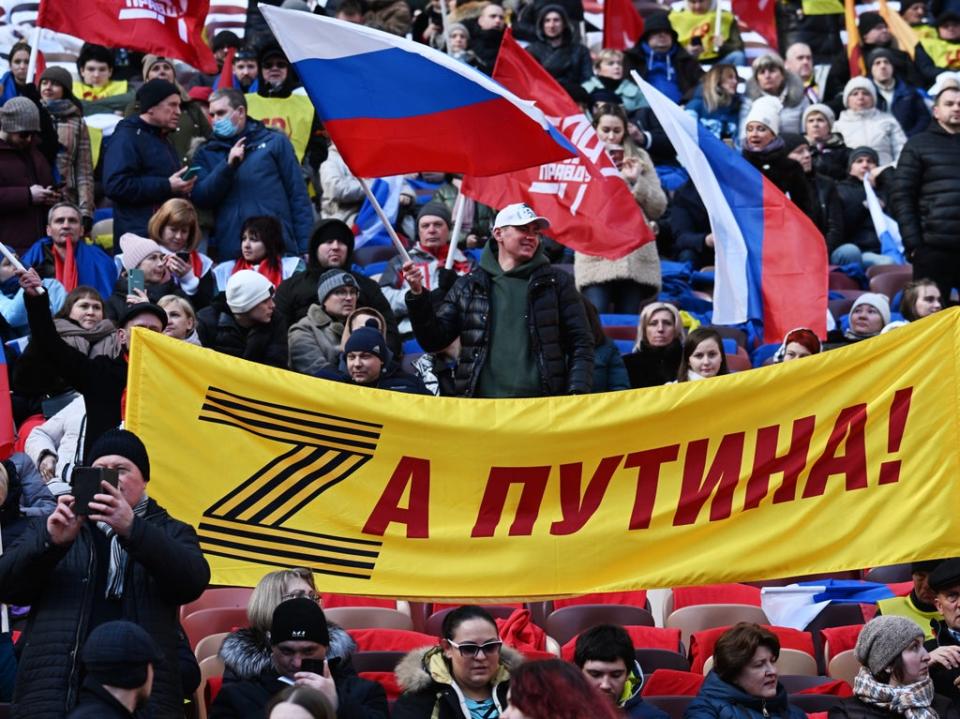 People hold a banner with letter Z and saying ‘For Putin!’ (EPA)