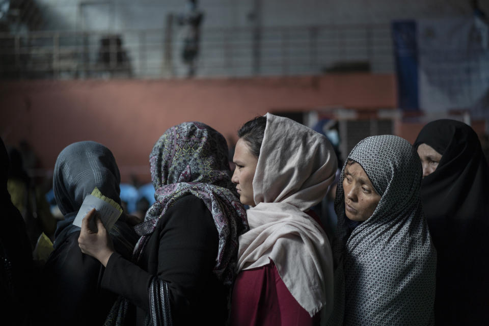 FILE - People wait in queues to receive cash at a money distribution organized by the World Food Program (WFP) in Kabul, Afghanistan, Wednesday, Nov. 3, 2021. UN World Food Program top official Mary-Ellen McGroarty says Afghanistan is facing a "tsunami of hunger," with the country on the verge of economic collapse and more than half of the population struggling to eat this winter. In an interview with The Associated Press on Thursday, Jan. 13, 2022 the WFP leader in Afghanistan urged the international community to separate political discussions from the humanitarian imperative by making sure the billions in aid that are required to avoid a disaster keep reaching the country, which is being run by the Taliban. (AP Photo/Bram Janssen, File)