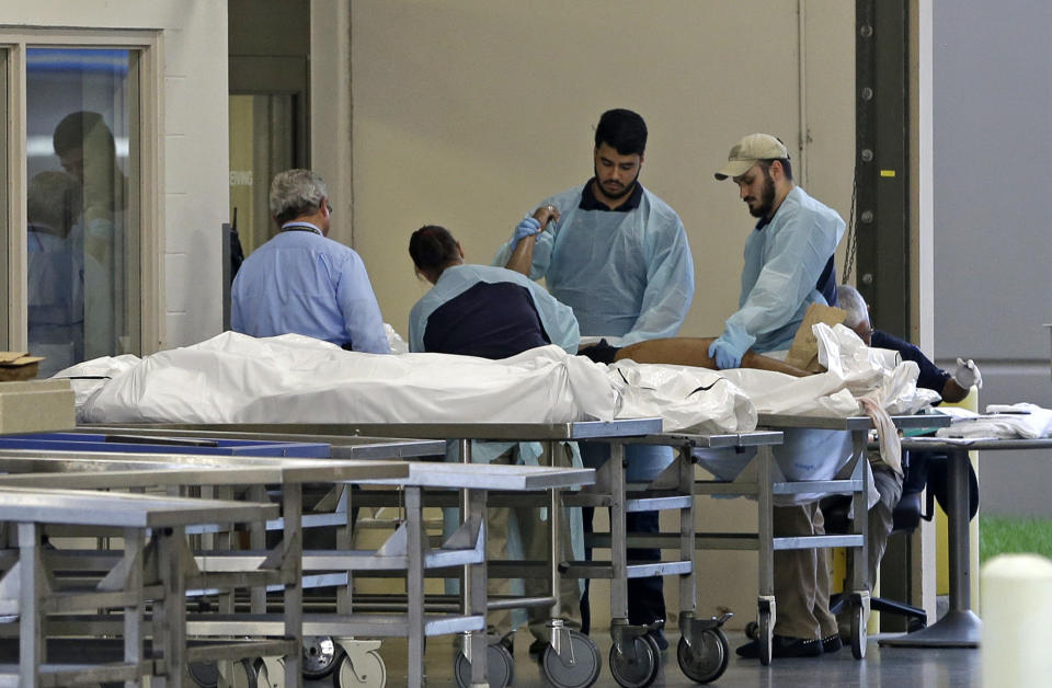 <p>Medical personnel examine a body at the Orlando Medical Examiner’s Office , Sunday, June 12, 2016, in Orlando, Fla. A gunman opened fire inside a crowded gay nightclub early Sunday, before dying in a gunfight with SWAT officers, police said. (AP Photo/Alan Diaz) </p>