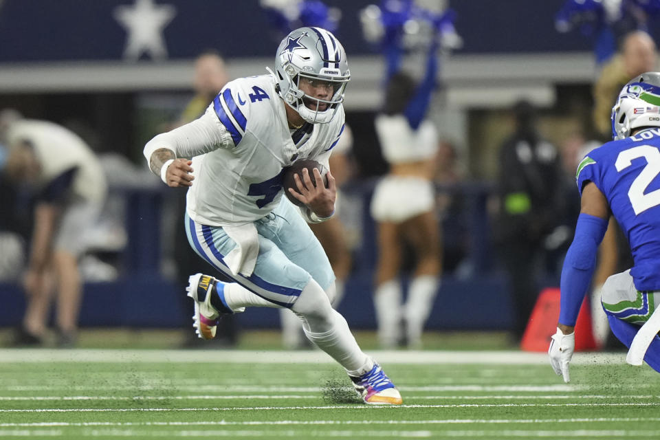 Dallas Cowboys quarterback Dak Prescott (4) eyes Seattle Seahawks safety Julian Love (20) as he rushes with the ball during an NFL football game, Thursday, Nov. 30, 2023, in Dallas, Texas (AP Photo/Peter Joneleit)