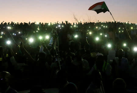 Sudanese demonstrators use their mobile phone torches as lamps as they attend a mass anti-government protest outside the Defence Ministry in Khartoum, Sudan, April 21, 2019. REUTERS/Mohamed Nureldin Abdallah