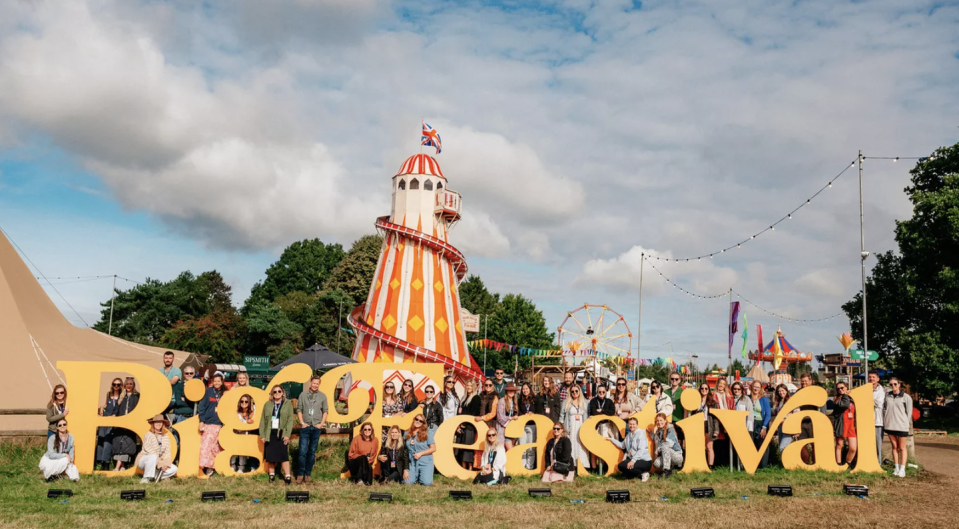 a group of people posing for a photo in front of a carnival ride