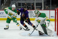 Minnesota Wild goaltender Cam Talbot (33) makes a save in front of Arizona Coyotes defenseman Alex Goligoski (33) as Wild defenseman Brad Hunt (77) defends in the second period during an NHL hockey game, Saturday, March 6, 2021, in Glendale, Ariz. (AP Photo/Rick Scuteri)