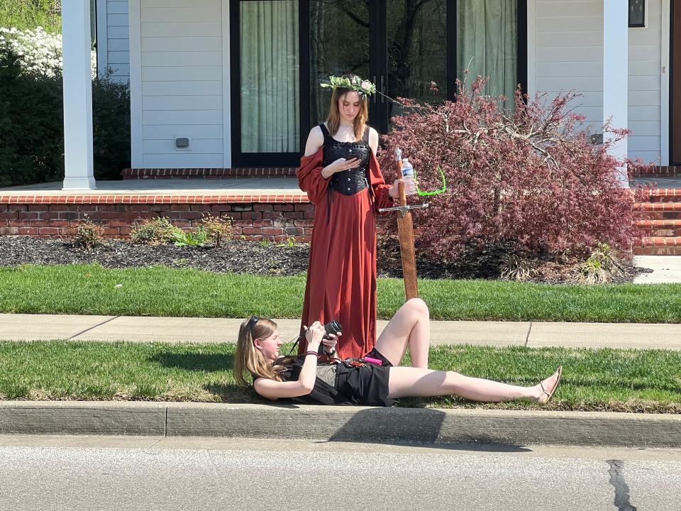 Bowling Green residents Sarah Evans, owner of S.C. Evans Photography, and Leah Moore look at eclipse photos on the camera and phone, respectively, minutes after totality along Henderson’s Water Street.