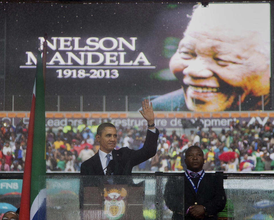 President Barack Obama waves as he arrives to speak to crowds attending the memorial service for former South African president Nelson Mandela at the FNB Stadium in Soweto near Johannesburg, Tuesday, Dec. 10, 2013.  (AP Photo/Evan Vucci)
