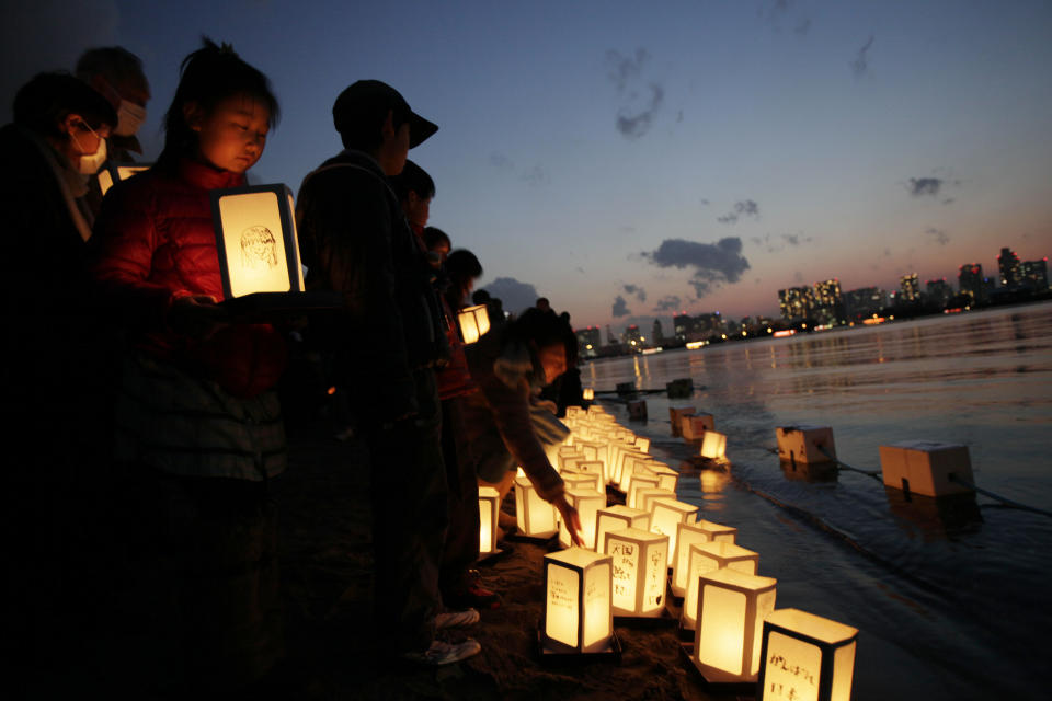 A girl waits her turn to release a lantern into the waters of Tokyo Bay to mark the anniversary of the earthquake and tsunami which devastated northeast Japan, in Tokyo, Sunday, March 11, 2012. People across Japan prayed and stood in silence on Sunday to remember the massive earthquake and tsunami that struck the nation one year ago, killing just over 19,000 people and unleashing the world's worst nuclear crisis in a quarter century. (AP Photo/Greg Baker)