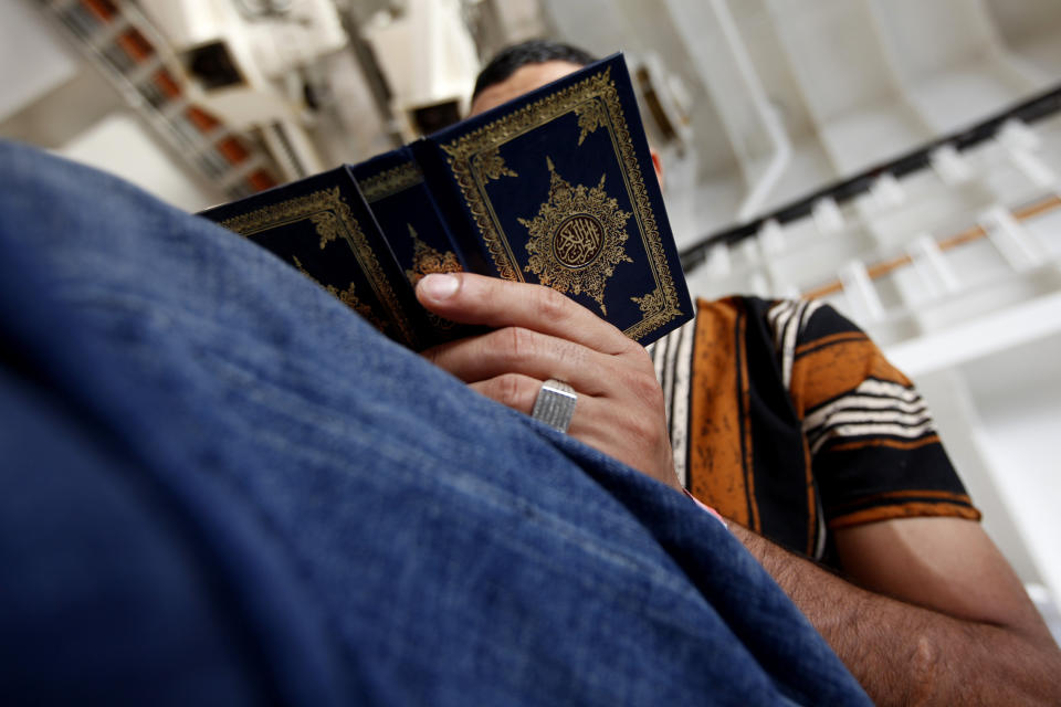 A Libyan migrant reads the Quran (Islam's Holy Book) on the deck of the Geo Barents, a rescue vessel operated by MSF (Doctors Without Borders) off Libya, in the central Mediterranean route, Wednesday, Sept. 22, 2021. (AP Photo/Ahmed Hatem)