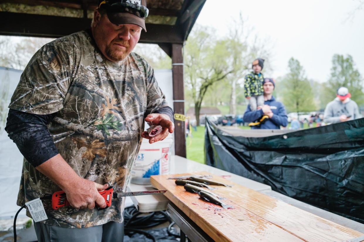 Greg Kipps of Tiffin cleans fish for anglers during the inaugural trout derby last weekend at the Tuscora Park Pond in New Philadelphia. Kipps owns and runs Twisted Lines Lake Erie Charters. He attended the event to provide free fish cleaning services.