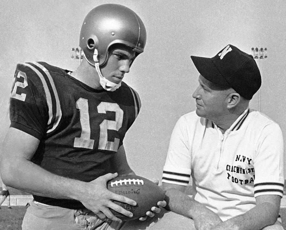 FILE - Navy coach Wayne Hardin talks with his star quarterback, Roger Staubach, in the final workout in Philadelphia Stadium on Dec. 7, 1963, before the annual battle against Army. Less than a month after President John F. Kennedy was assassinated, Army-Navy played what turned out to be one of the most memorable games in their storied rivalry. Trying to upset Heisman winner Staubach and the second-ranked Midshipmen, Army reached Navy's 2-yard line, trailing 21-15 in the closing seconds, but time ran out. (AP Photo/Bill Achatz, File)