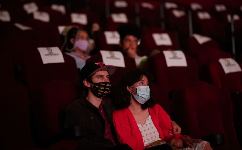 Moviegoers sit socially distanced as they wait for the movie "Godzilla vs. Kong" on the reopening day of the TCL Chinese theatre during the outbreak of the coronavirus disease (COVID-19), in Los Angeles