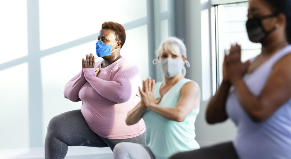 People wearing masks and doing yoga in an office