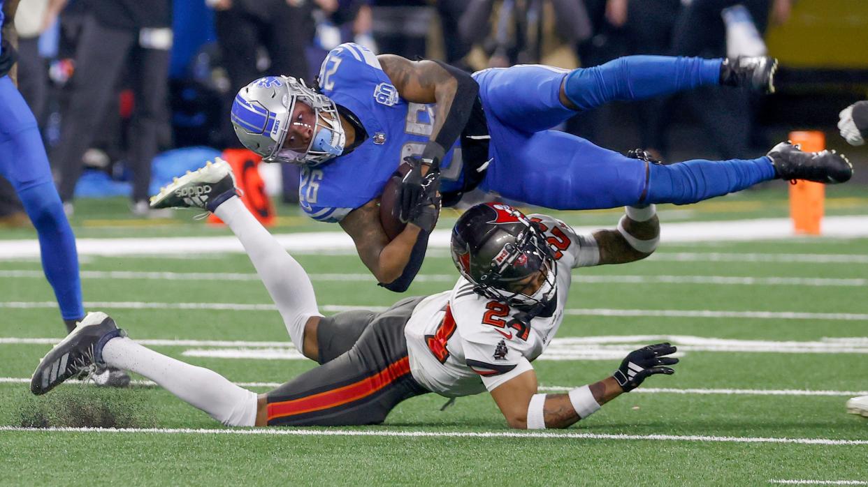 Detroit Lions running back Jahmyr Gibbs gets upended on a tackle by Tampa Bay Buccaneers cornerback Carlton Davis III during the second half in the playoff game at Ford Field in Detroit on Sunday, Jan. 21, 2024.