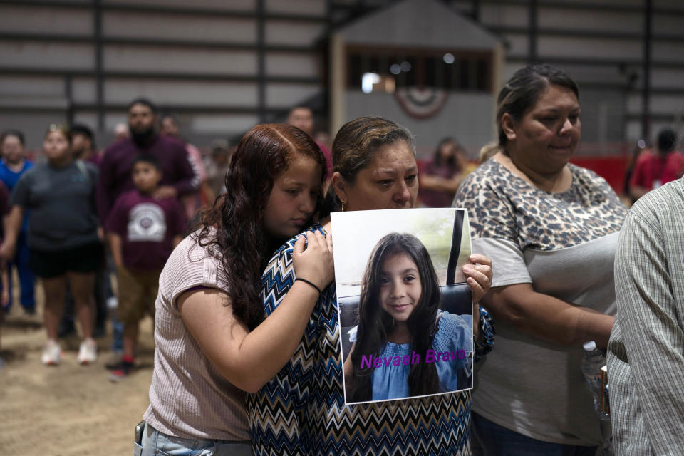 Esmeralda Bravo, en el centro, sostiene una foto de su nieta Nevaeh, una de las víctimas del tiroteo en la Escuela Primaria Robb, mientras es consolada por la prima de Nevaeh, Anayeli, durante una vigilia de oración el miércoles 25 de mayo de 2022, en Uvalde, Texas. (AP Foto/Jae C. Hong)