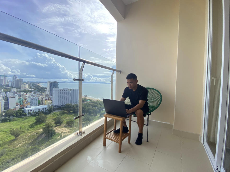 AP journalist Hau Dinh works on a laptop during a virus lockdown in Vung Tau, Vietnam on Sept. 13, 2021. Dinh set off from Hanoi for the seaside resort for a long weekend in mid-July. The trip came just as the delta variant began sweeping through Vietnam, sparking harsh lockdown measures that left him trapped away from home. Nine weeks later, he's still there. (AP Photo/Mathieu Le Besq)