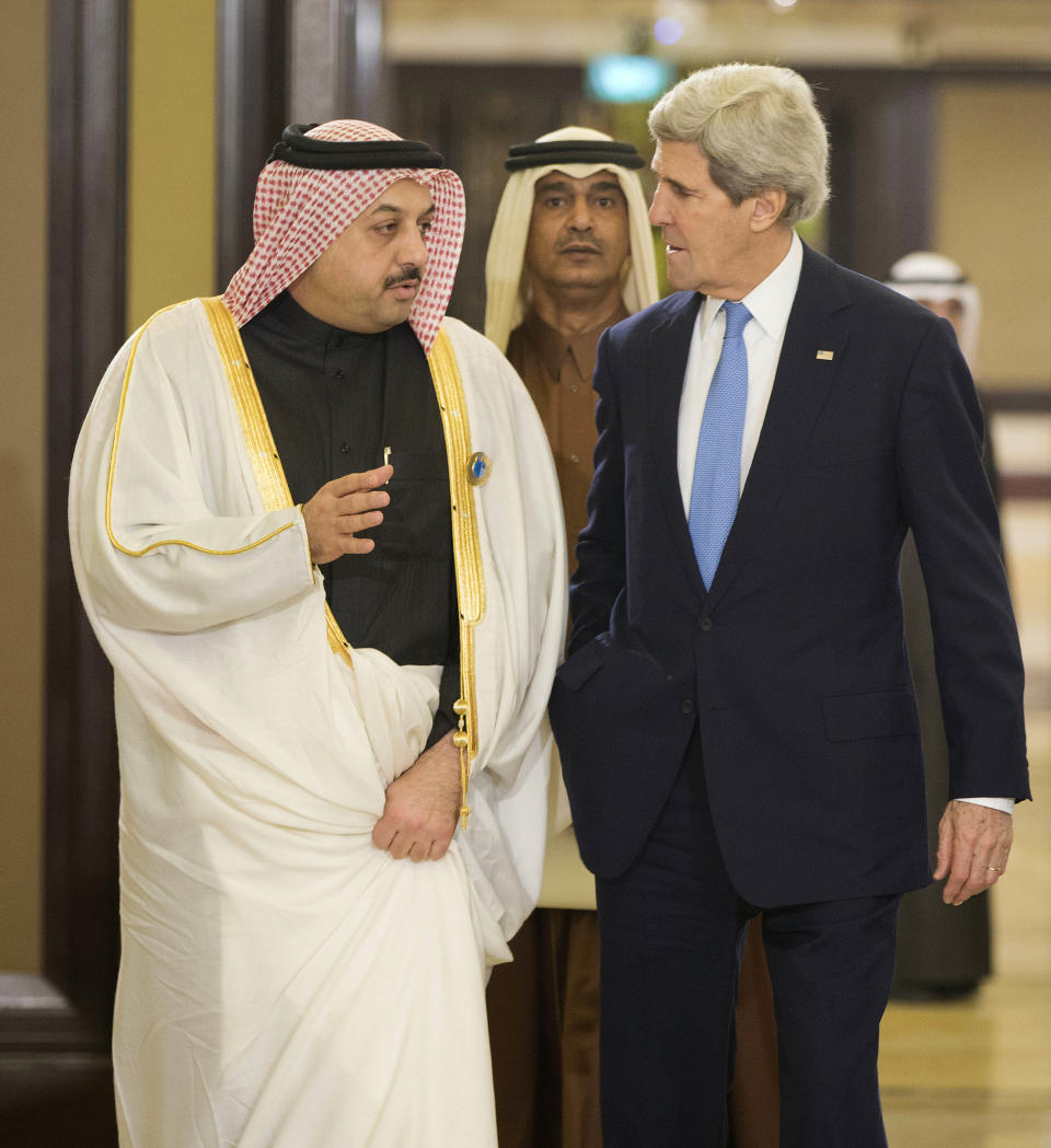 U.S. Secretary of State John Kerry, right, talks with Qatar's Foreign Minister Khalid bin Mohammed al-Attiyah,left, before the opening session of the Syria Donors' Conference at Bayan Palace in Kuwait, Wednesday, Jan. 15, 2014. (AP Photo/Pablo Martinez Monsivais, Pool)