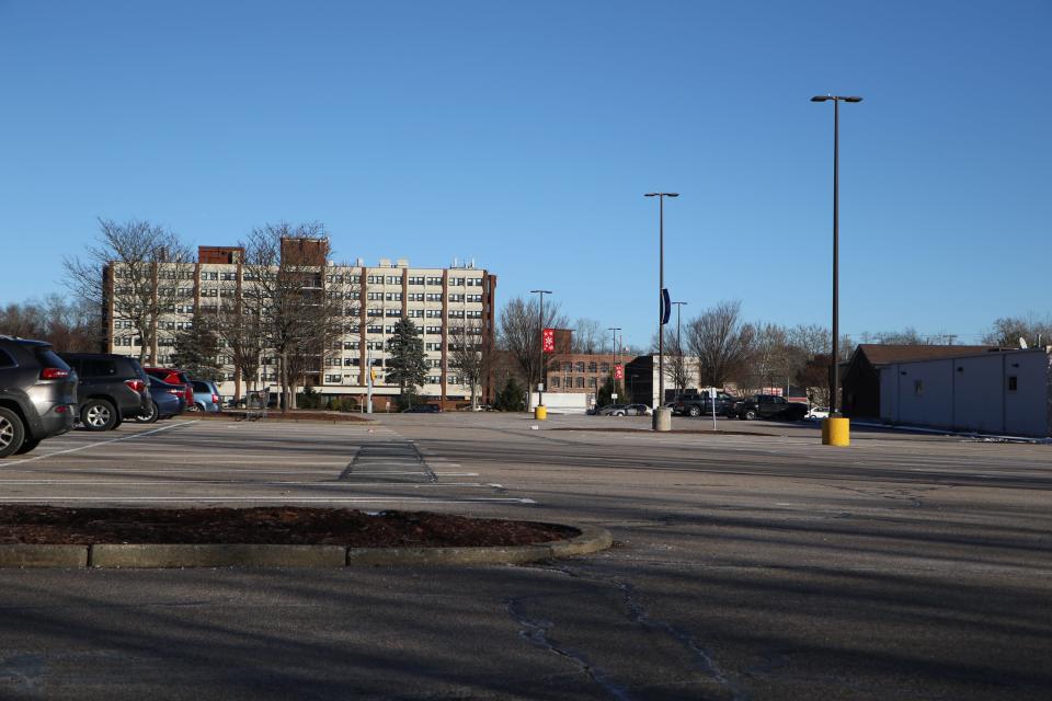 A consultant has suggested that this sprawling parking lot and a strip-mall to the right would make a good site for housing. The Cumberland Manor high-rise is across Mendon Road in the background.