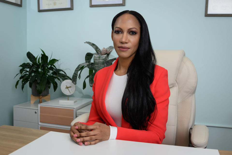 Dr. Judith Joseph sitting in an office chair at a desk, possibly in her office