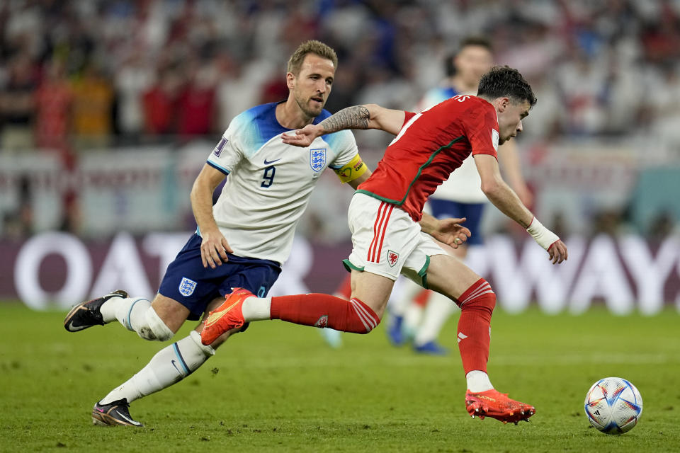 Wales' Neco Williams, right, and England's Harry Kane battle for the ball during the World Cup group B soccer match between England and Wales, at the Ahmad Bin Ali Stadium in Al Rayyan , Qatar, Tuesday, Nov. 29, 2022. (AP Photo/Abbie Parr)