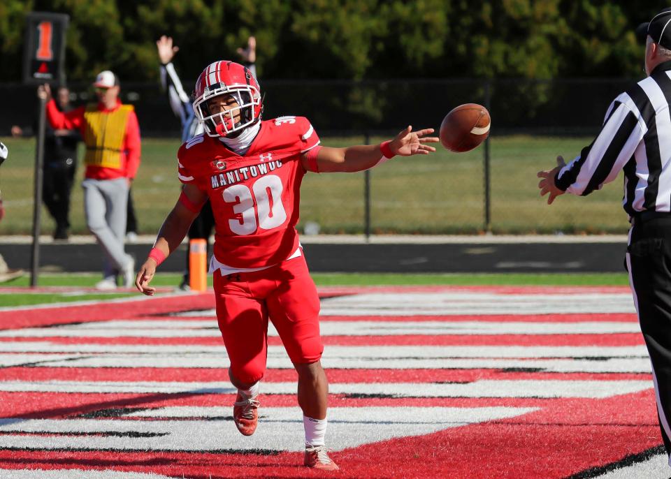 Manitowoc Lincoln’s Mack Beasley (30) tosses the ball to the referee following a touchdown against Green Bay East on Saturday Ron Rubick Field in Manitowoc.