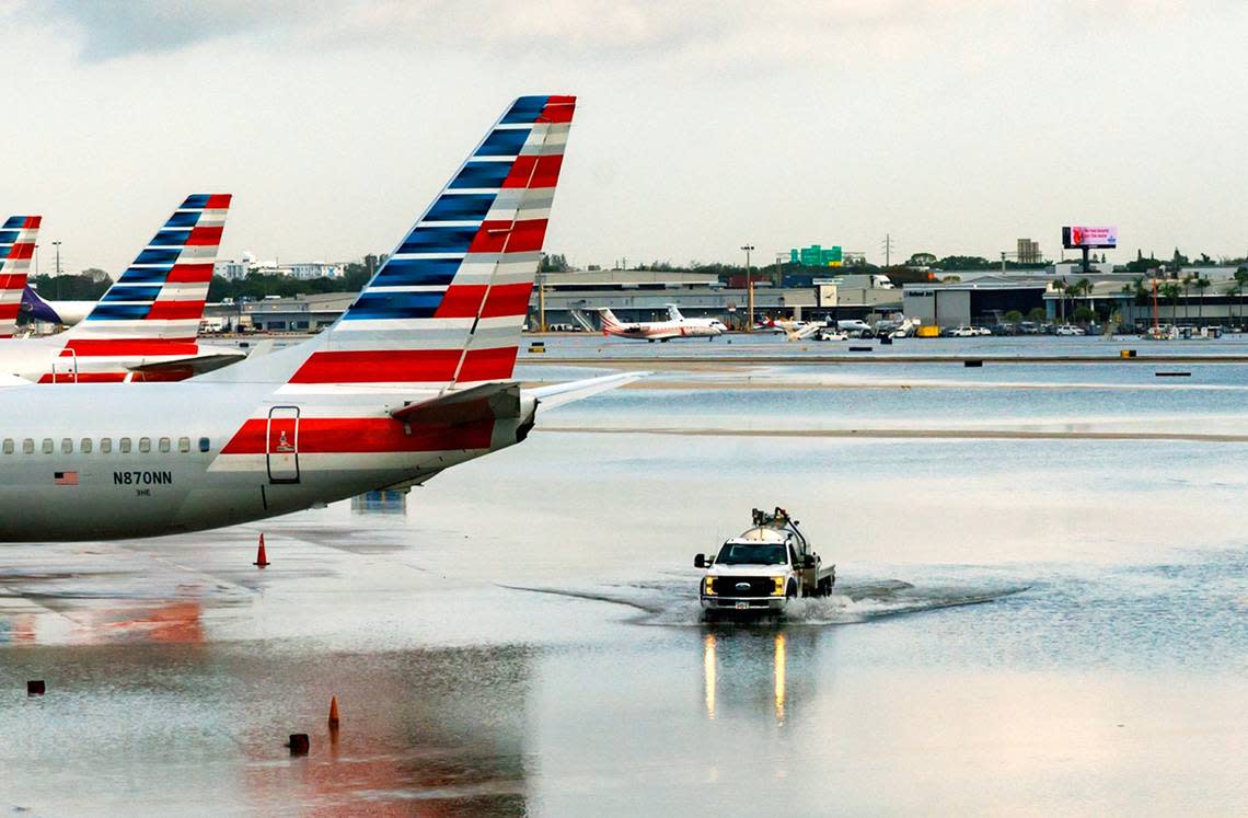 American Airlines airplanes at their terminal as a truck drives through the flooded tarmac at the Fort Lauderdale-Hollywood International Airport on Thursday, April 13, 2023.