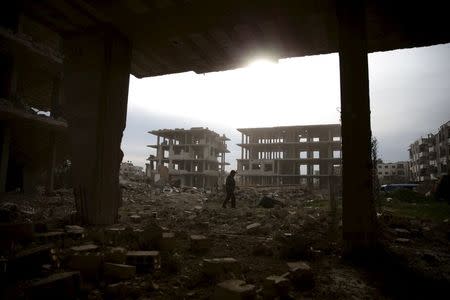 A man walks on the rubble of damaged buildings in the rebel-controlled area of Jobar, a suburb of Damascus, Syria March 2, 2016. REUTERS/Bassam Khabieh