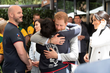 BritainÕs Prince Harry and Meghan, the Duchess of Sussex meet Team UK competitors while attending a lunchtime Reception hosted by the Prime Minister with Invictus Games competitors, their family and friends in the cityÕs central parkland Sydney October 21, 2018. The Prince gives Team UK vice-captain Michelle Turner a hug. Paul Edwards /Pool via REUTERS