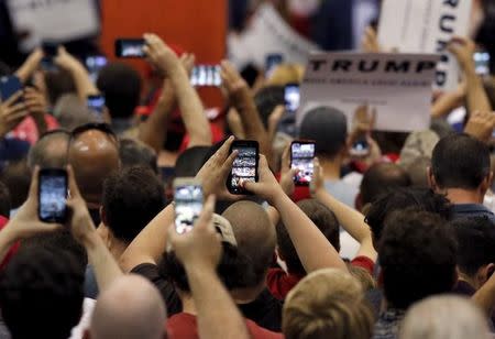 Members of the audience hold up their smart phones as Republican U.S. Presidential candidate Donald Trump speaks during a campaign event in Tucson, Arizona in this photo taken March 19, 2016. REUTERS/Sam Mircovich