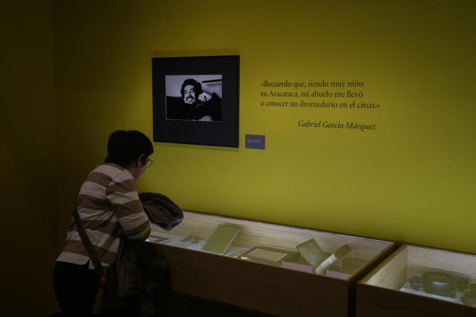 Una mujer observa el legado "in memoriam" del escritor colombiano Gabriel García Márquez, bajo un retrato suyo, dentro de una exposición en la sede del Instituto Cervantes, en Madrid, el 24 de abril de 2024. (AP Foto/Paul White)